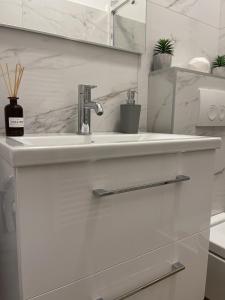 a white bathroom with a sink and a mirror at Apartment Meri in Korčula +19 photos