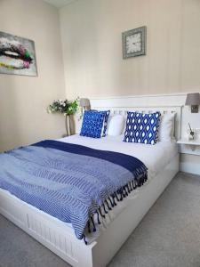 a bedroom with a large bed with blue and white pillows at St Johns Boutique Hotel in London