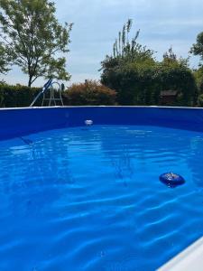 a blue swimming pool with a slide in the background at Casa Serenella in Piazzola sul Brenta