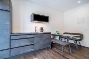 a room with a kitchen and a table and a tv at Naturapartments Alpreid Tanne in San Pancrazio dʼUltimo +9 photos