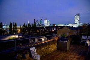 a balcony with a view of a city at night at Large Shoreditch 2DBL bed loft apt in London
