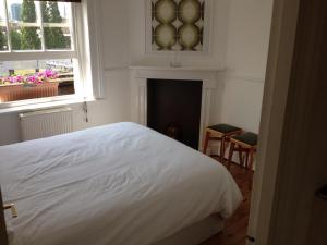 a bedroom with a white bed and a fireplace at Large Shoreditch 2DBL bed loft apt in London