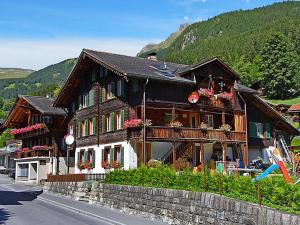 a large wooden building with flowers on the windows at Chalet Spillstatt in Grindelwald