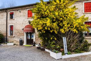 a building with a yellow tree in front of it at La Locanda degli Artisti in Medelana