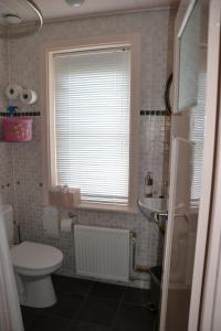 baño con aseo y lavabo y ventana en B&B MACBED CHECKIN-TIME 1700-1800 or request before you book, en Alkmaar