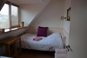 a small bedroom with a bed with a purple pillow at B&B MACBED CHECKIN-TIME 1700-1800 or request before you book in Alkmaar +14 photos
