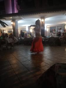 Beldibi的住宿－Santana Hotel，穿着红色衣服在餐厅跳舞的女人