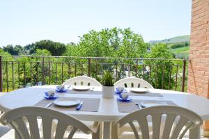 a white table with white chairs on a balcony at Homiday - Appartamenti Tamerici in Pineto