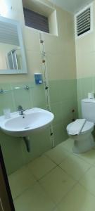 La salle de bains blanche est pourvue d'un lavabo et de toilettes. dans l'établissement Santana Hotel, à Beldibi