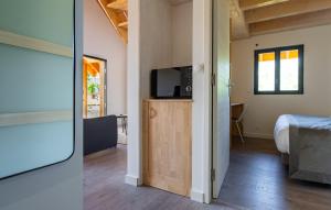 a room with a bed and a television on a cabinet at Les Cottages de Ripaille in Thonon-les-Bains