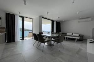 a kitchen and a dining room with a table and chairs at Premier Laguna Apartment in Lovište