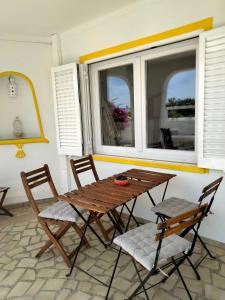 a wooden table and chairs in a room with a window at Vila Horizonte in Carvoeiro