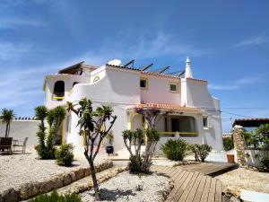 a white house with palm trees in front of it at Vila Horizonte in Carvoeiro