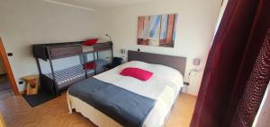 um quarto com uma cama com uma almofada vermelha em Ferienwohnung-Haustaedter-Muehle em Lahnau