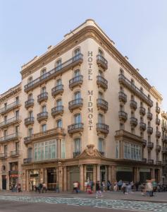Un gran edificio con gente caminando frente a él. en Hotel Midmost by Majestic Hotel Group, en Barcelona