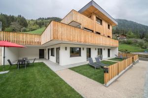 a house with a patio with a table and chairs at Naturapartments Alpreid Tanne in San Pancrazio dʼUltimo