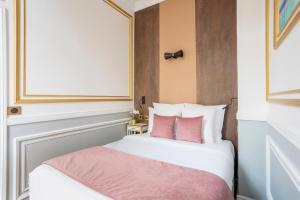 a bedroom with a white bed with pink pillows at Luxury 3 bedrooms 2 Bathrooms - Ile saint-Louis in Paris