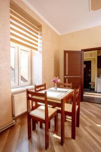 a dining room with a table and chairs with flowers on it at Apartments Rynok Square 12 in Lviv