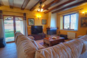 uma sala de estar com um sofá e uma televisão em Villa Can Roig by Hello Homes Sitges em Sant Pere de Ribes