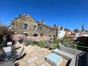 a patio with chairs and tables in front of a building at The Red Lion Inn Alnmouth in Alnmouth