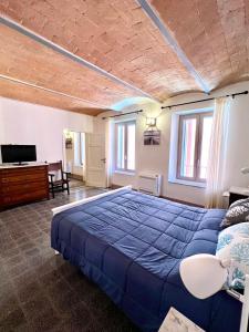 a bedroom with a large blue bed and windows at Guest house Le due lagune in Orbetello