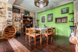 a dining room with green walls and a table and chairs at Apartments Miona in Virpazar
