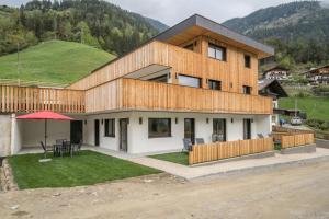 una casa con una colina verde en el fondo en Naturapartments Alpreid Fichte, en San Pancrazio 7 fotos más
