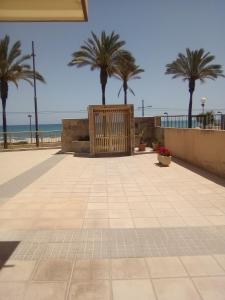 un patio con palmeras y la playa en Apartamento Voramar Primera Linea de Mar, en El Campello