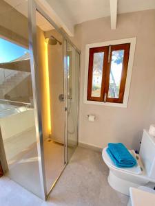 a bathroom with a glass shower and a toilet at Sa Punta Dúplex Cala Ratjada in Cala Ratjada