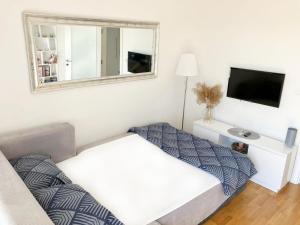 - une petite chambre avec un lit et un miroir dans l'établissement Cozy nest SAVADA, à Belgrade