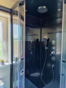 een badkamer met een douche en een glazen wand bij Lianko - Vakantiewoning in Bekkevoort