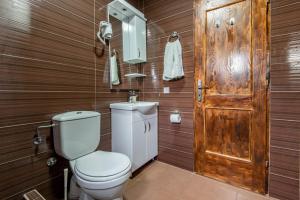a bathroom with a toilet and a wooden wall at Apartments MIONA in Virpazar
