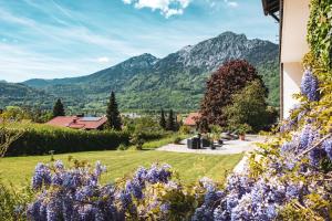 a garden with purple flowers and mountains in the background at Villa Sonnenhof Boutique-Hotel in Bad Reichenhall