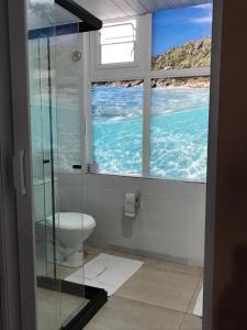 a bathroom with a view of the ocean through a window at Pousada Recanto do Arraial do Cabo in Arraial do Cabo
