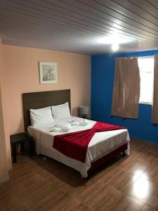 a bedroom with a large bed in a blue room at Pousada Recanto do Arraial do Cabo in Arraial do Cabo