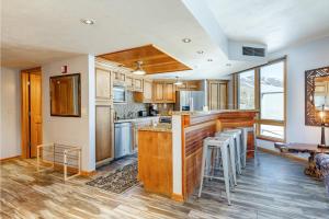 a kitchen with a bar with stools in it at The Caledonian in Park City