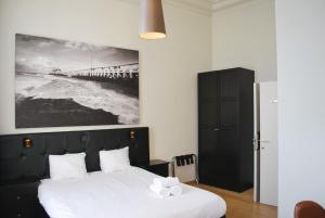 ein Schlafzimmer mit einem Bett und einem Bild eines Piers in der Unterkunft Hotel Le Parisien in Ostende