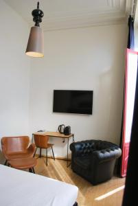 Una televisión o centro de entretenimiento en Hotel Le Parisien