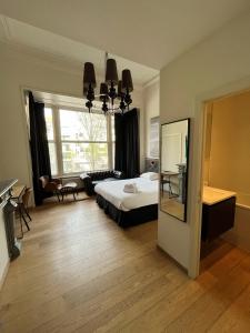 ein Schlafzimmer mit einem Bett und einem großen Fenster in der Unterkunft Hotel Le Parisien in Ostende