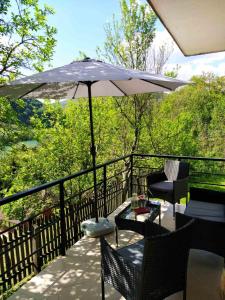 um pátio com um guarda-sol, cadeiras e uma mesa em Drinski pogled em Bajina Bašta