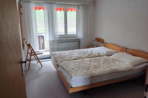een slaapkamer met een bed en 2 ramen bij Haus Panorama Reeling - CharmingStay in Flumserberg