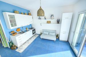 cocina con armarios blancos y suelo de baldosa azul en Villa La Falesia, en Realmonte