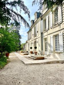 eine Reihe von Gebäuden mit Bänken davor in der Unterkunft Le Clos du Roc in Montlouis-sur-Loire