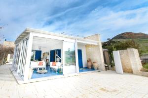 a white house with glass doors and a patio at Villa La Falesia in Realmonte