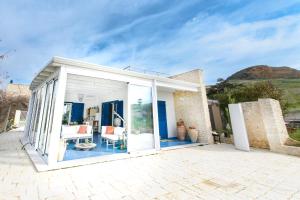 Casa blanca con puertas de cristal y patio en Villa La Falesia, en Realmonte