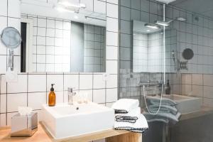 a bathroom with a white sink and a mirror at Hôtel Le Collonges in Brive-la-Gaillarde +40 photos
