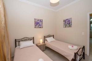 deux lits jumeaux dans une chambre avec deux tableaux au mur dans l'établissement Lollas Apartments Acharavi Corfu, à Acharavi 41 autres photos