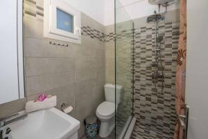 une salle de bains avec douche, toilettes et lavabo dans l'établissement Lollas Apartments Acharavi Corfu, à Acharavi