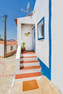 a staircase leading to a house with blue and white walls at CASA DA ALDEIA II in Alcaria Ruiva