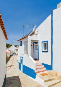 a white and blue building with blue doors and stairs at CASA DA ALDEIA II in Alcaria Ruiva